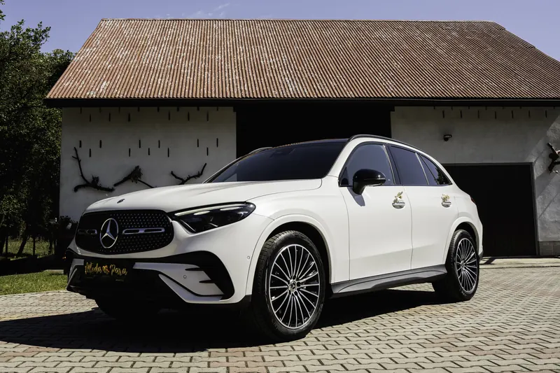 Biały Mercedes GLC przed stodołą