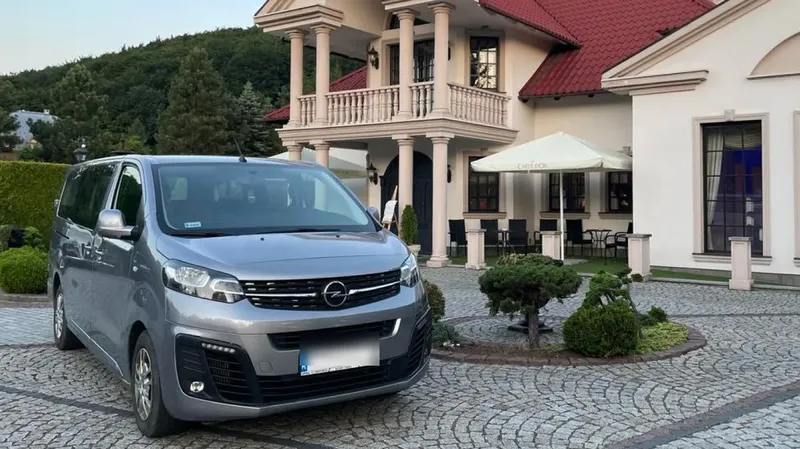 Srebrny Opel Vivaro przed rezydencją